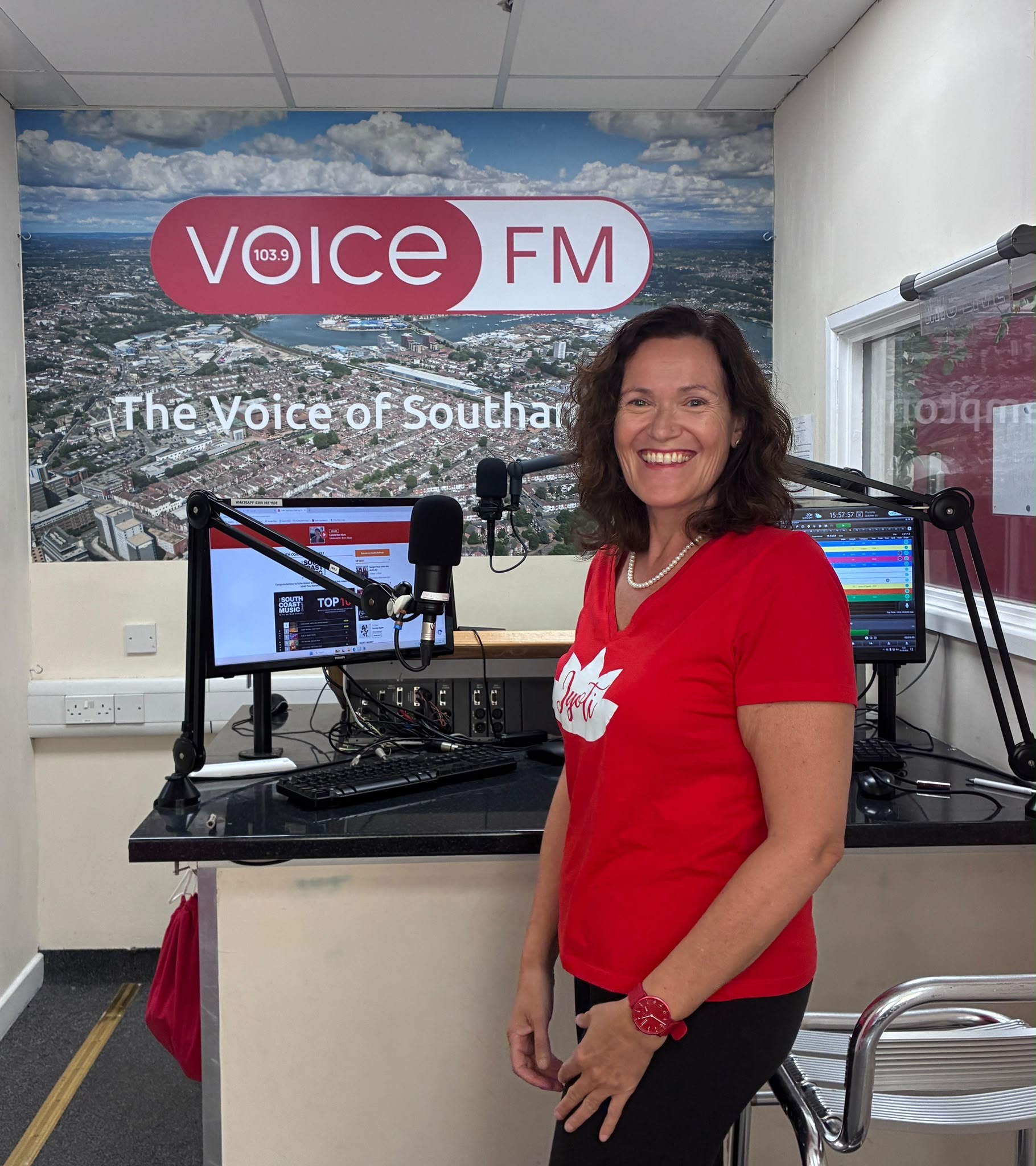 Jyoti Harvey beside the microphones at the Voice FM studio